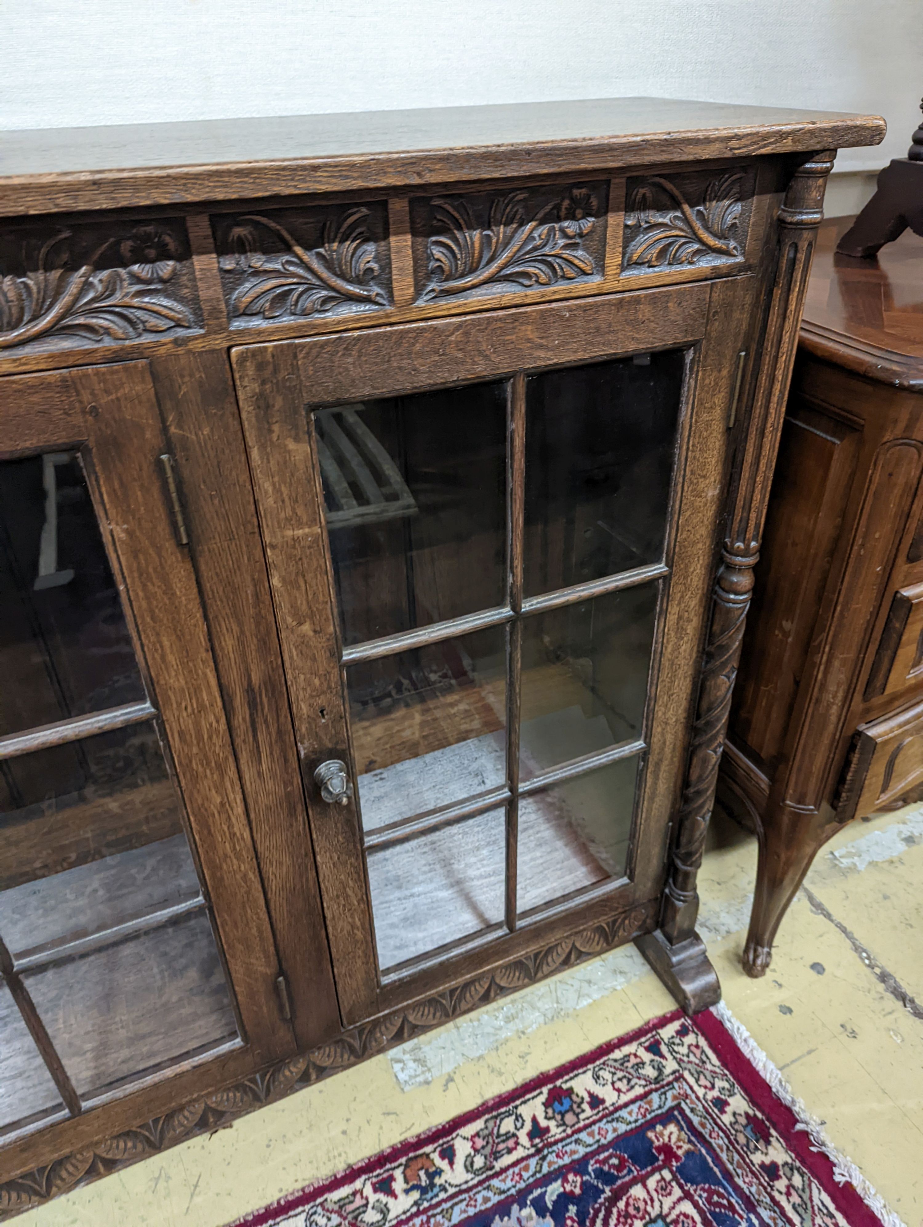 A 17th century style oak glazed low bookshelf. W-152cm, D-38cm, H-100cm.